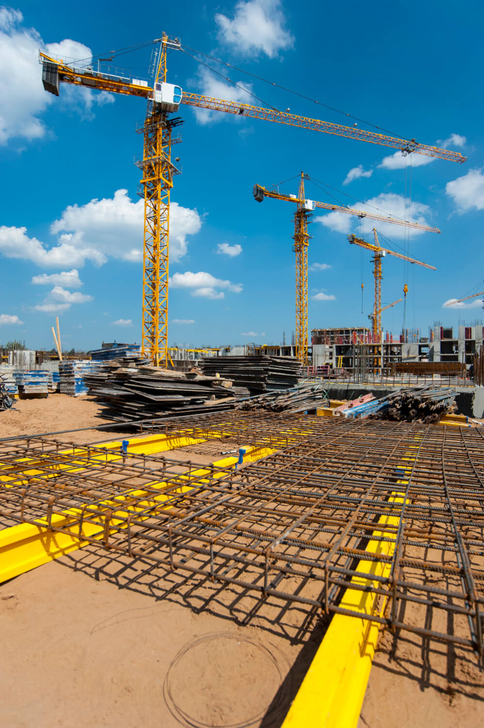 Schalen f&uuml;r Beton auf einer Baustelle mit Baukr&auml;nen im Hintergrund